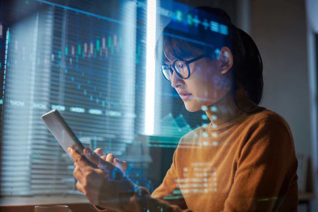 Person searching on tablet with blue metrics overlaid.